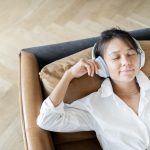 A woman listens to her favorite tracks of music in a mobile application with headphones.
