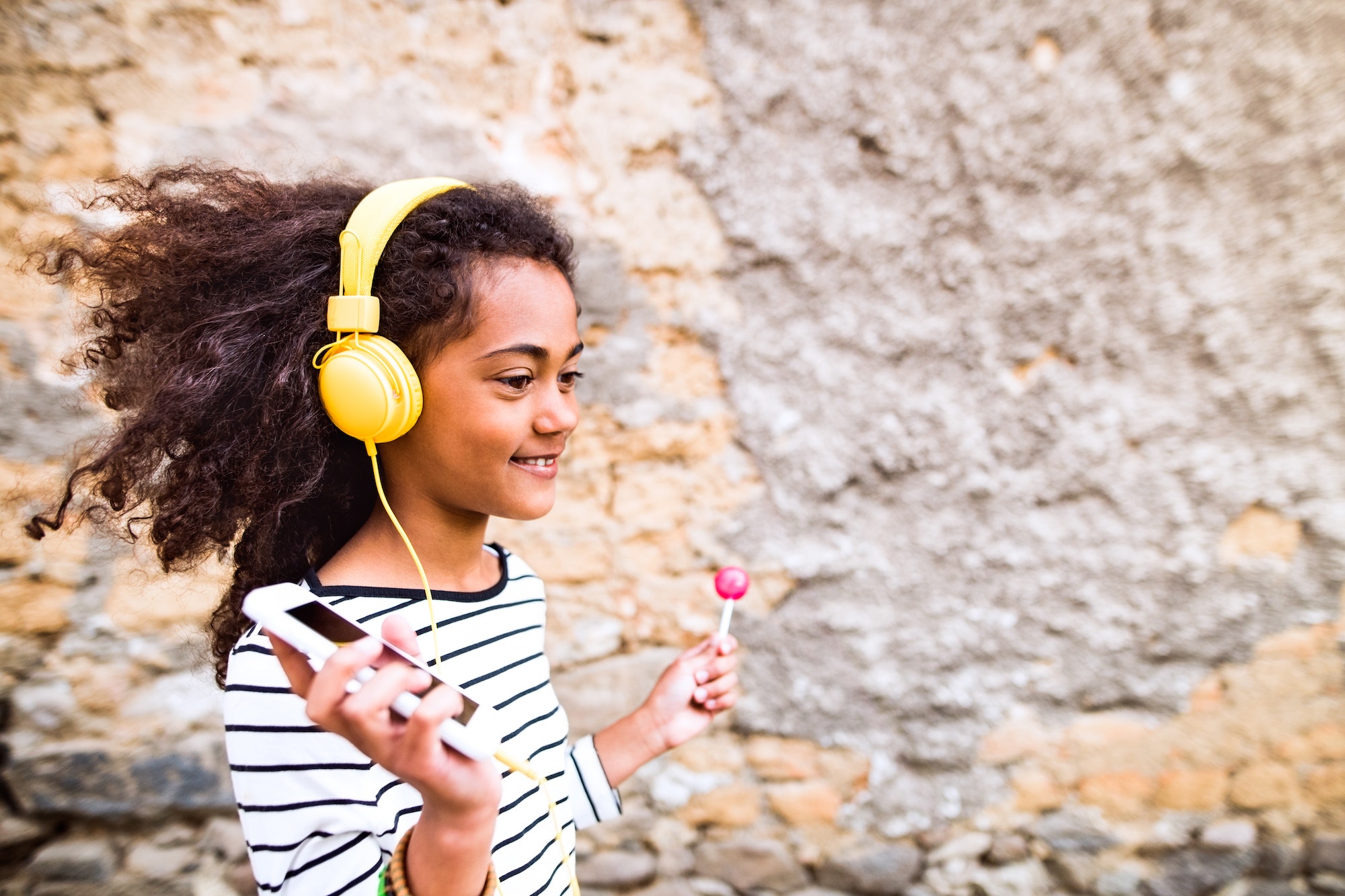 Beautiful african american girl with headphones, listening music